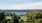 a soccer field with trees with a lake in the background