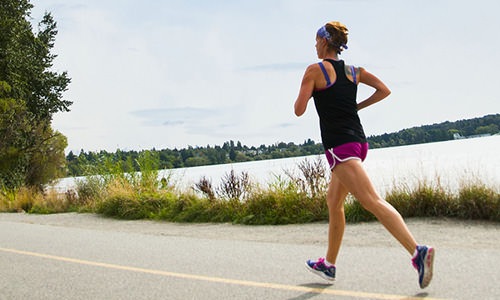 woman takes a run along a lake